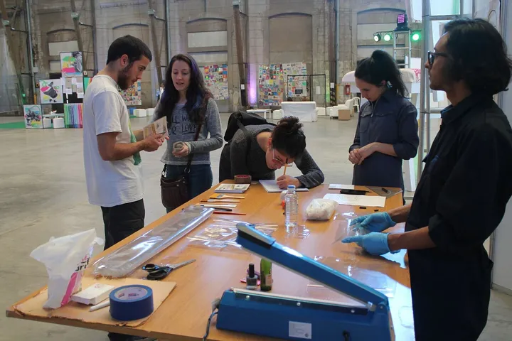 Conserve is a site-specific work conducted by The Triangular Collective in September 2018 in the university community of Santa Fe (Argentina). The work included a performative action of gathering objects from the community, simultaneously excavating a hole in the ground for a subsequent ritual burial of these objects. In the image we are receiving the objects donated to be part of the Conserve.